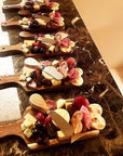 Set of charcuterie boards with assorted meats, cheeses, and fruits on a marble surface.