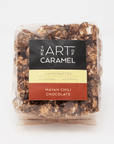 A clear plastic bag of 'The Art of Caramel' handcrafted caramel popcorn in the 'Mayan Chili Chocolate' flavor, shown against a plain white background.