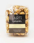 A clear plastic bag of 'The Art of Caramel' handcrafted caramel popcorn in the 'Vanilla Bean Cocoa Nib' flavor, shown against a plain white background.
