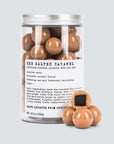 Jar of salted caramel chocolate covered liquorice with a label on a light gray background