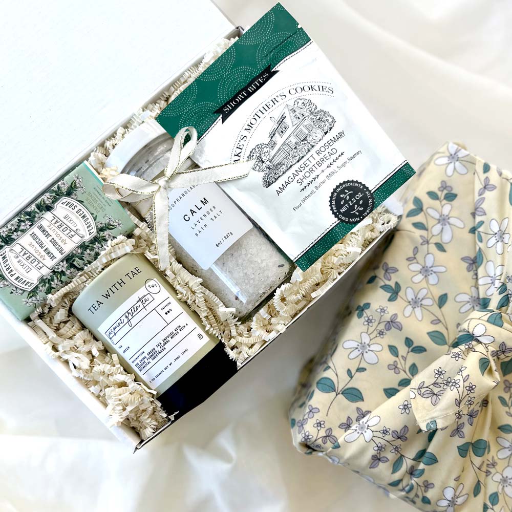 kadoo calm spa curated gift box wrapped in reusable furoshiki fabric wrap. gifts included lavender bath salt, rosemary shortbread, jasmine soap, jasmine tea and more