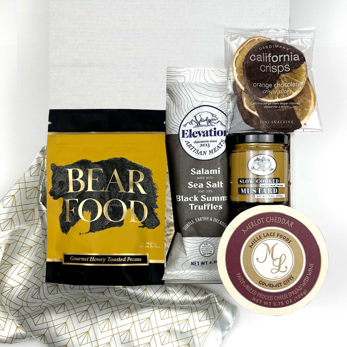 kadoo gift box cheese and charcuterie. Inside gift box: peanuts, salami, orange chocolate slice, mustard, cheese spread, gold white fabric wrap and more.