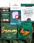 kadoo curated holiday gift box with eleven madison home granola, browny gourmet coffee, pretzel, rosemary shortbread, dark chocolate, green fabric wrapand more