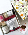kadoo birthday celebration gift box with happy birthday candle, champagne sugar bath treats, green tea, shortbread & more. Wrapped in reusable Furoshiki fabric.