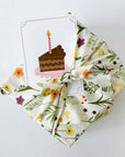 gift box with furoshiki fabric wrap and birthday cake greeting card