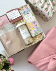 kadoo rose garden gift box for her in furoshiki fabric wrap. Gifts include: bath soak, relax bath salt, farmhouse biscuit, handmade soap, rose quartz facial roller and more.