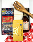 kadoo pasta night curated gift box with dry pasta, chocolate bar, homemade tomato sauce, yellow stripes kitchen towel, olive wooden fork utensil, red fabric wrap, and more
