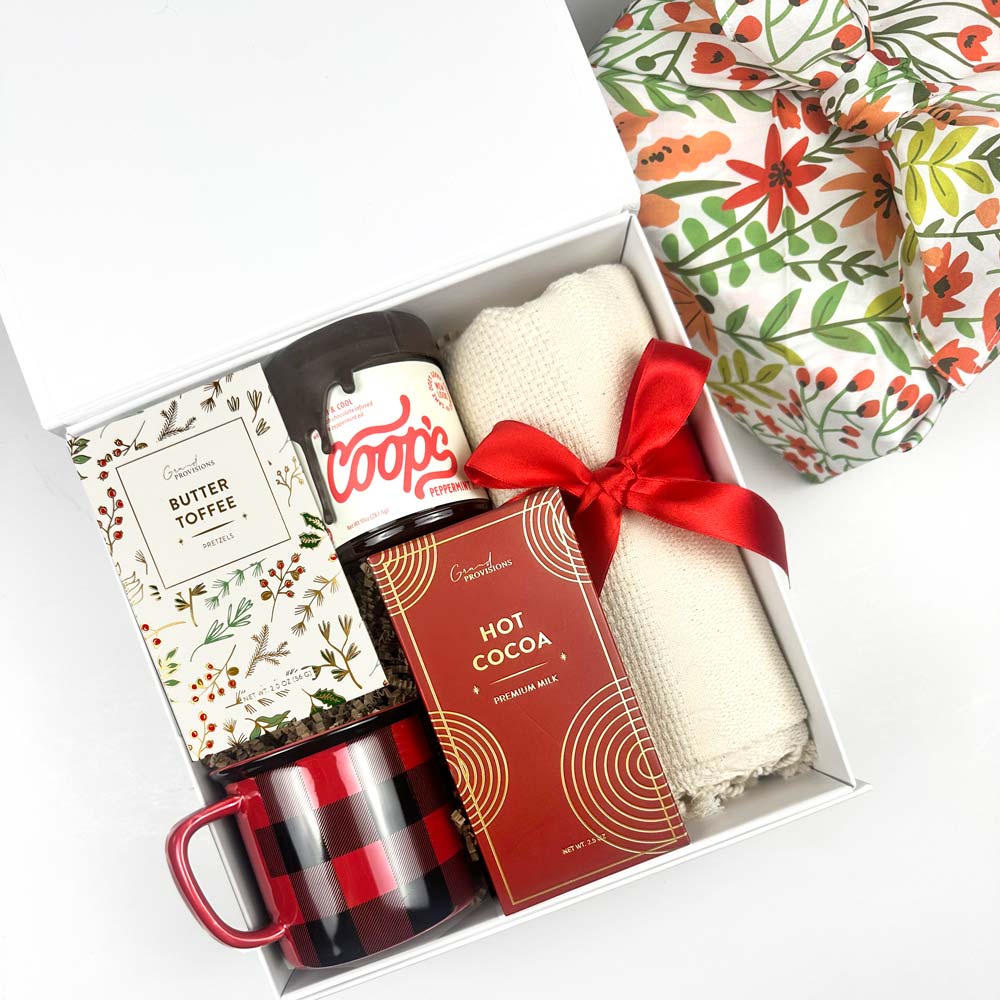 Gift set with Coop's hot fudge peppermint, cocoa mix, mug, and blanket and more in a decorative holiday box.