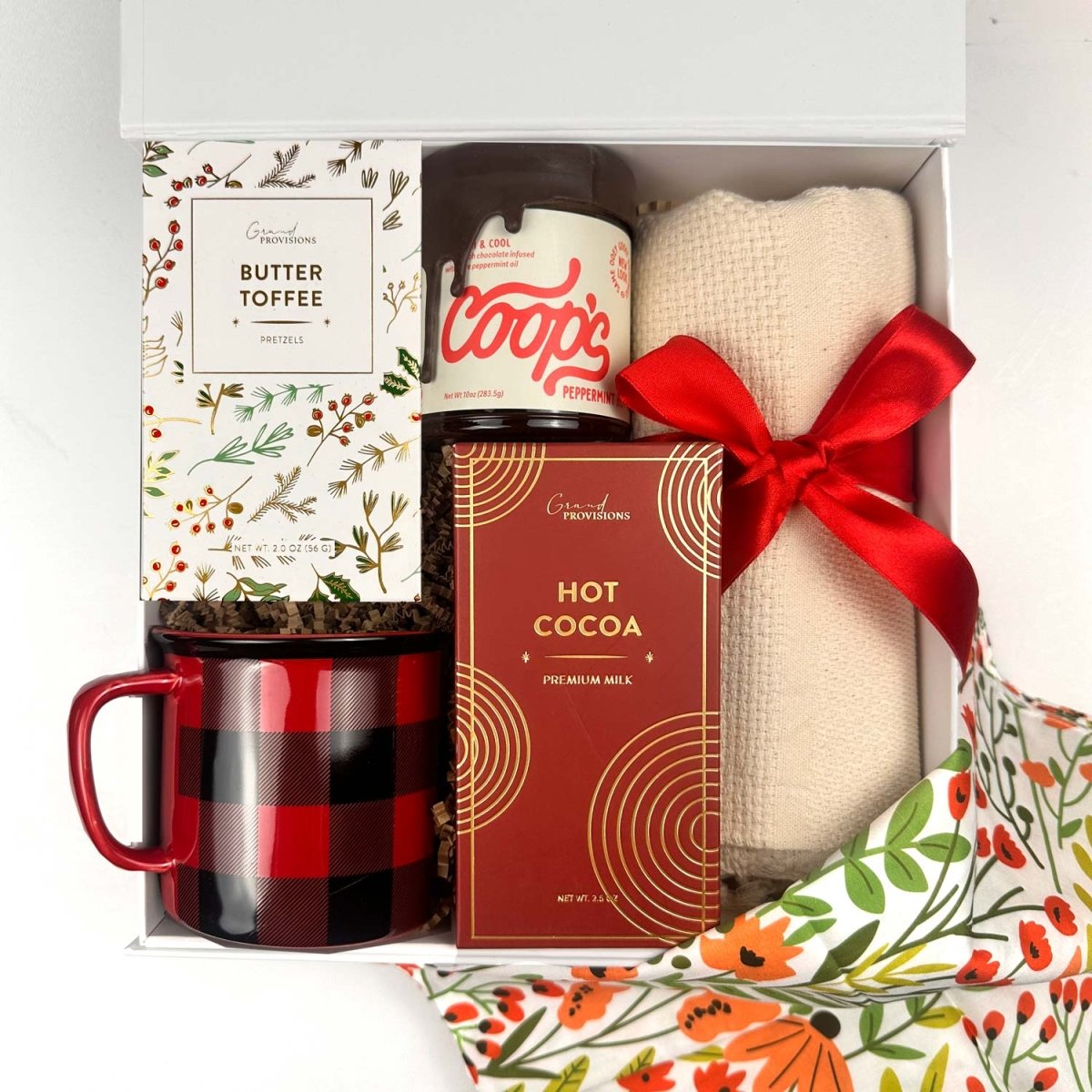 Gift set with Coop's peppermint fudge, mug, blanket, hot cocoa, butter toffee pretzels and more, in a decorative box.