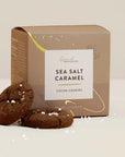 Box of Sea Salt Caramel Cocoa Cookies with two cookies in front on a light background