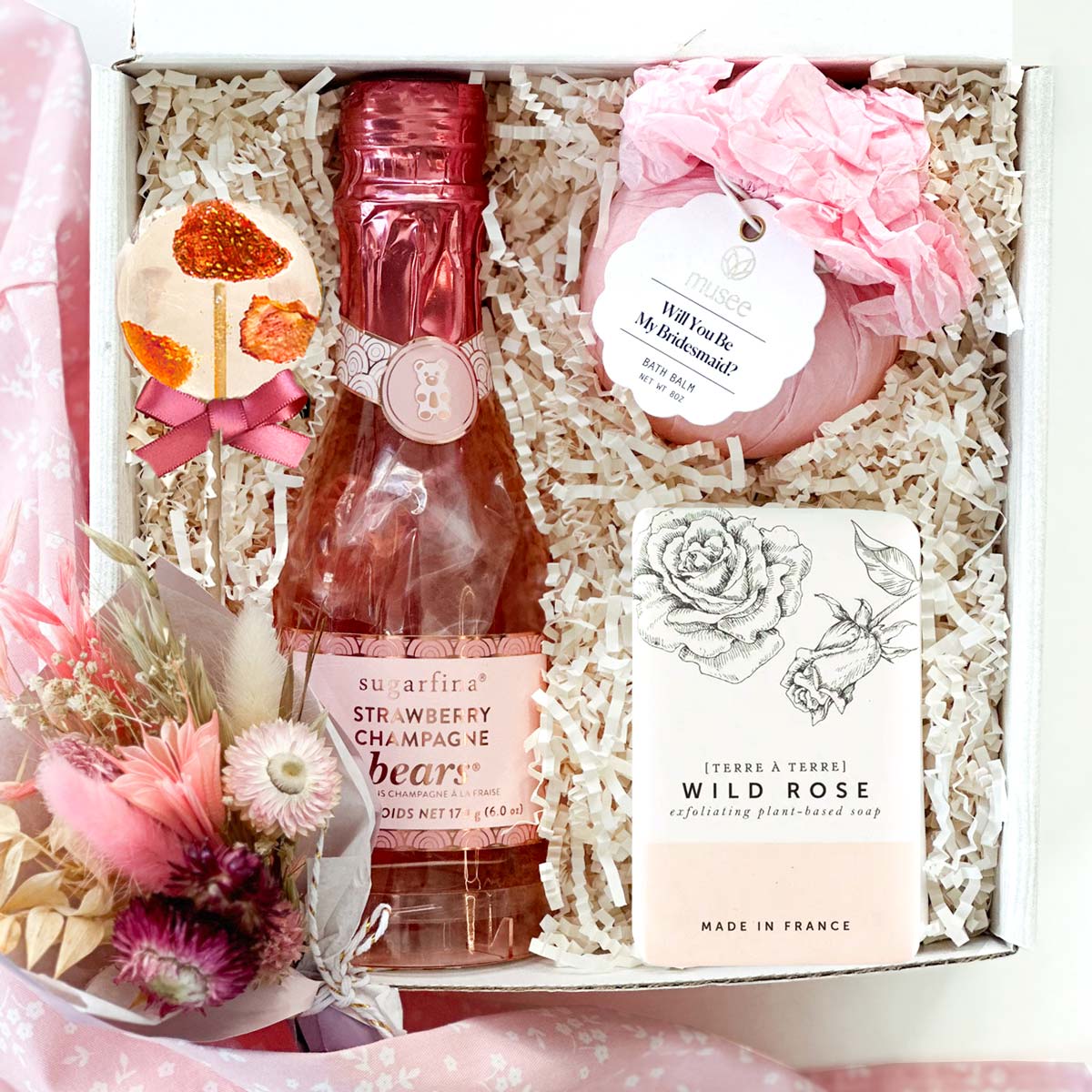 kadoo bridesmaid furoshiki gift box for your wedding party. will you be my bridesmaid bath balm, sugarfina champagne bear, lollipop, & bar soap.