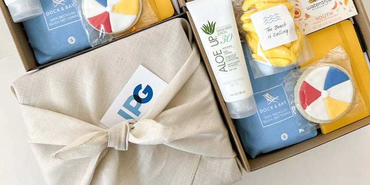 kadoo custom curated gift boxes for IPG, filled with custom cookies, sustainable towel, custom candy, sunscreen and more.