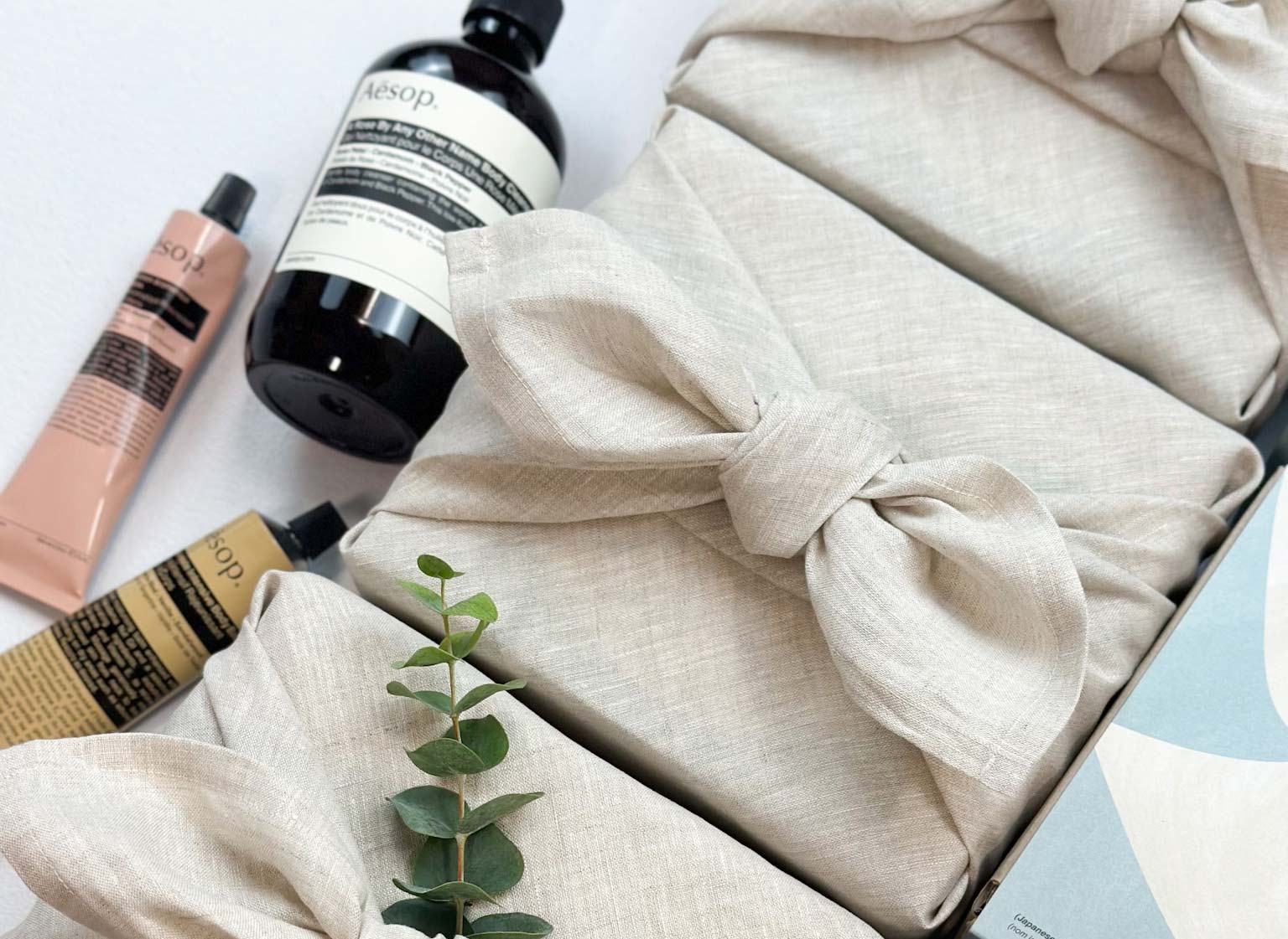 Skin beauty AESOP  products with a decorative bow on a light background