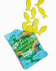 A package of opened BonBon Sour Elderflower Fish gummy candies, with several yellow fish-shaped gummies coming out of the bag on a plain white background.