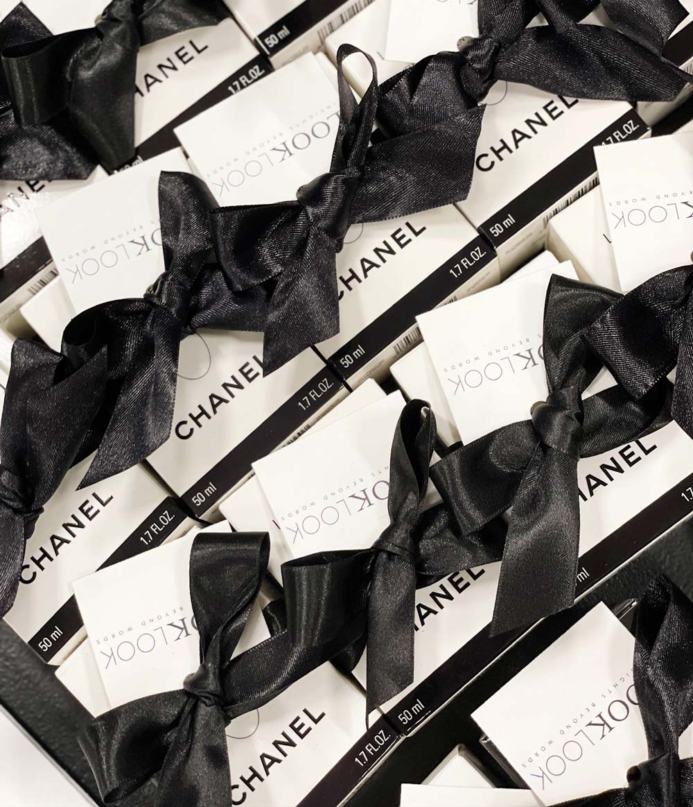 Chanel makeup with black ribbons on a white background