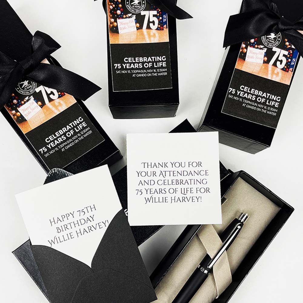Gift boxes with '75th Birthday' pen set, and card on a white background