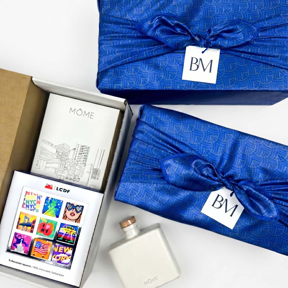 Blue gift box with 'BM' label, Mème product, and bottle on a white background