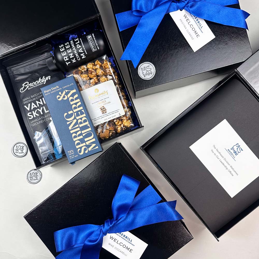 Gift box with blue ribbons, snacks, and drinks on a white surface