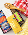 Kadoo gift set with a wooden fork, pasta, sauce, chocolate, and tea towel with furoshiki wrapping.