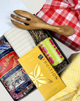 Kadoo gift set with a wooden fork, pasta, sauce, chocolate, and tea towel with furoshiki wrapping.