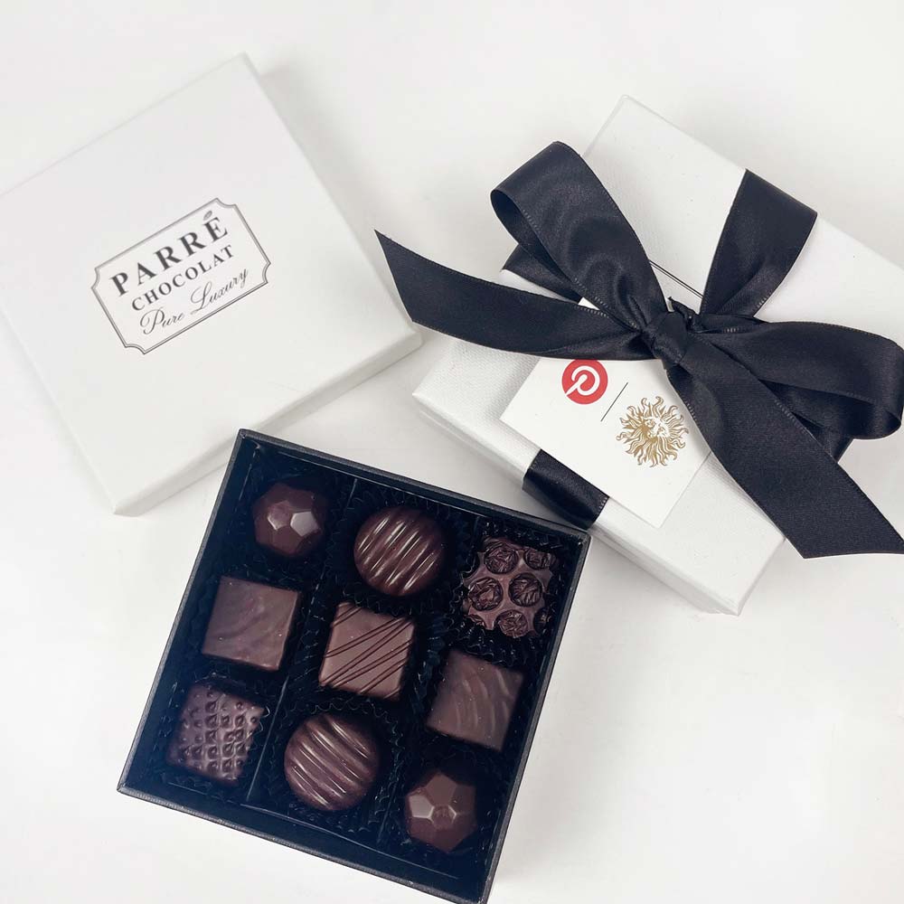 Box of chocolates with a black ribbon and 'Parre Chocolat' branding on a white background