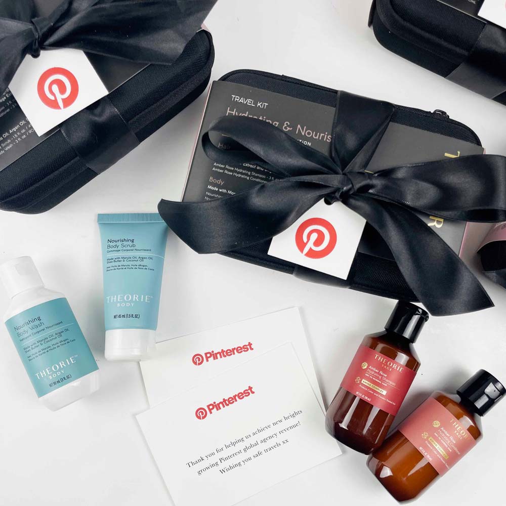 Skincare travel kit with bottles and a black bow on a white background, featuring Pinterest branding.