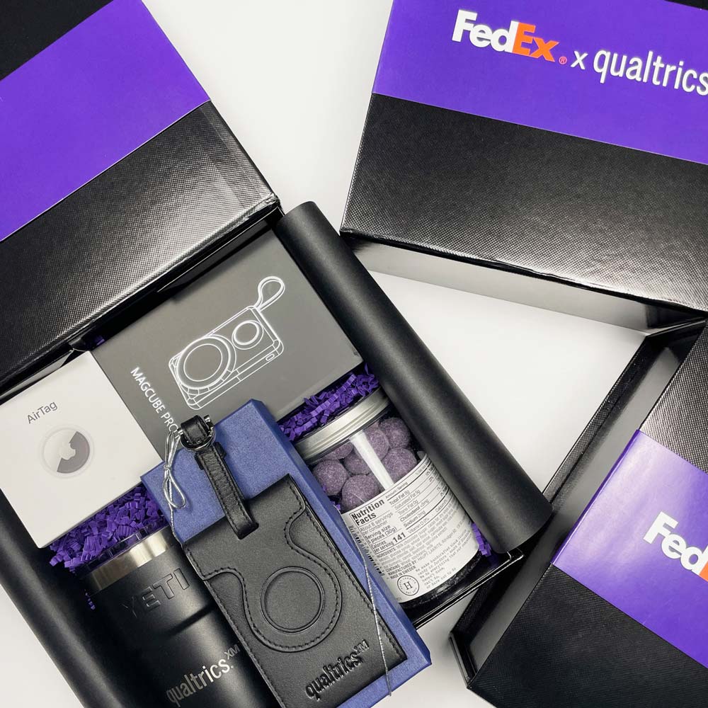 fedex qualtrics black gift box with airtag, branded tumbler, lugagge tag, charger, and snack