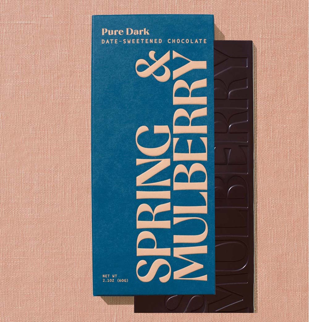Spring &amp; Mulberry chocolate bar with blue packaging on a beige background