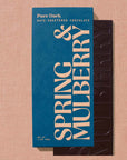 Spring & Mulberry chocolate bar with blue packaging on a beige background