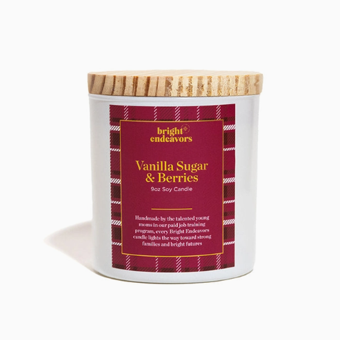 A white glass jar of Bright Endeavors Vanilla Sugar &amp; Berries candle with a light wood lid and a dark red label on a clean white background.
