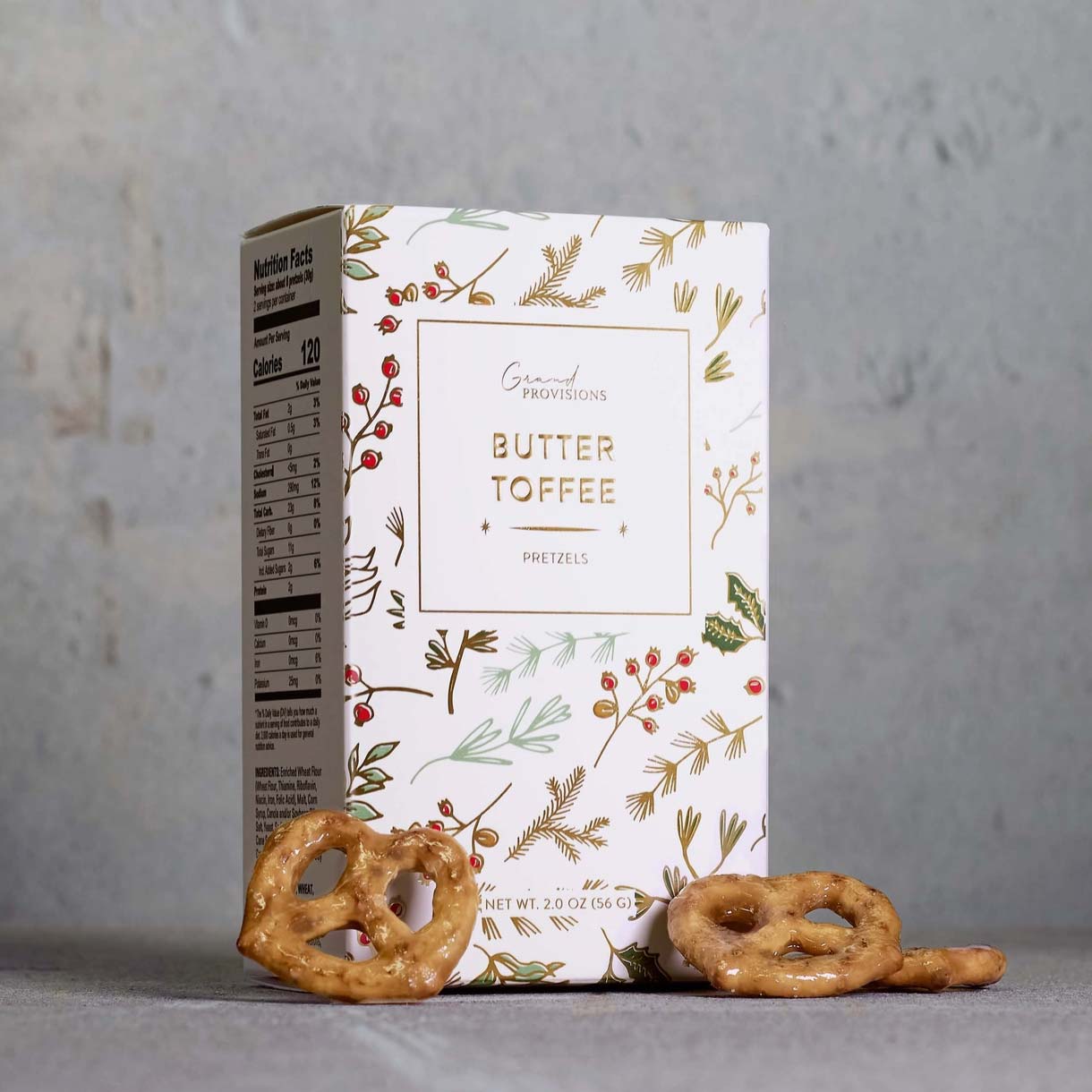 Butter toffee pretzel by Grand Provisions packaging with pretzels on a gray background