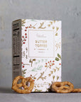 Butter toffee pretzel by Grand Provisions packaging with pretzels on a gray background