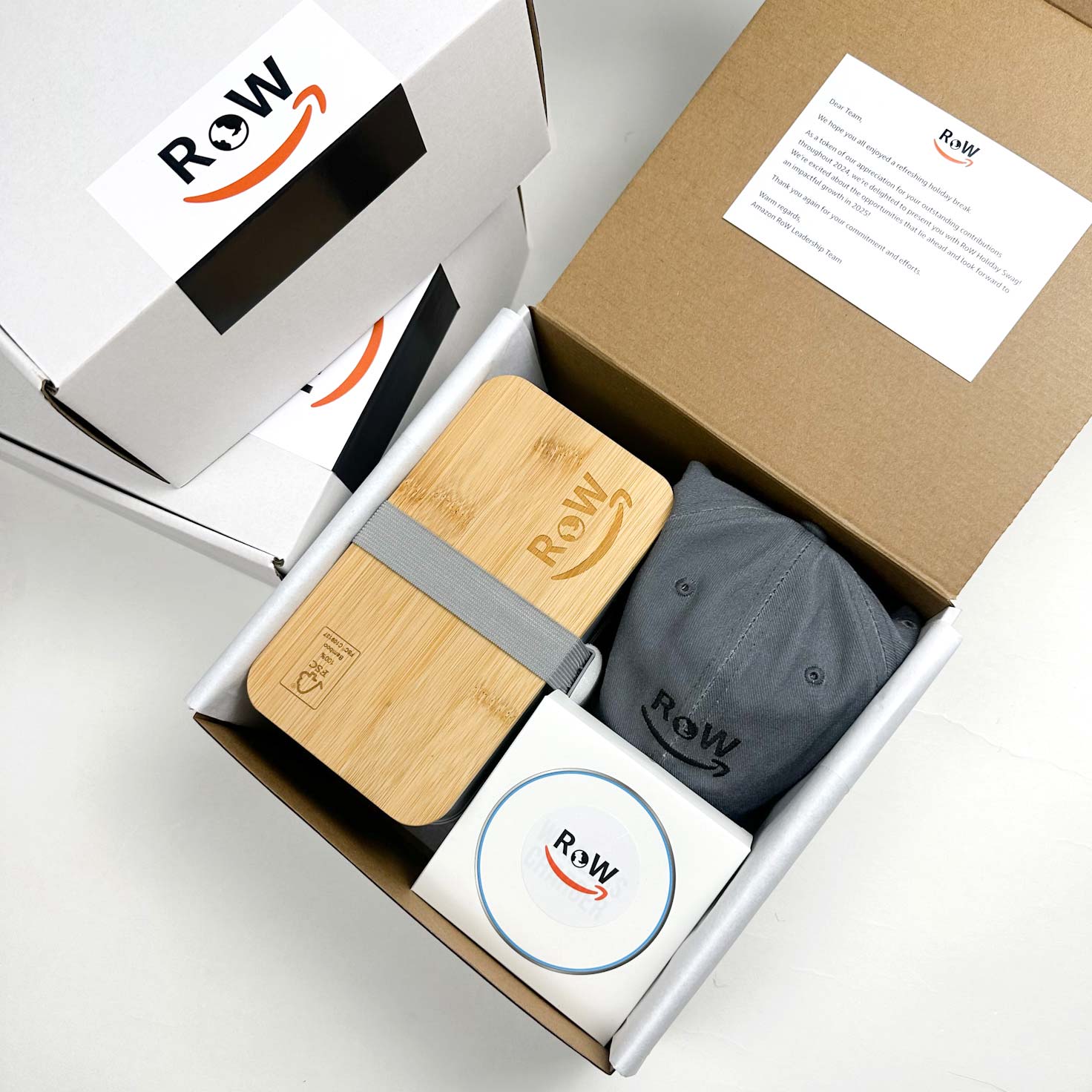 Amazon Row Corporate gifts for team division. Branded bento box, branded hat, and branded wireless charger.