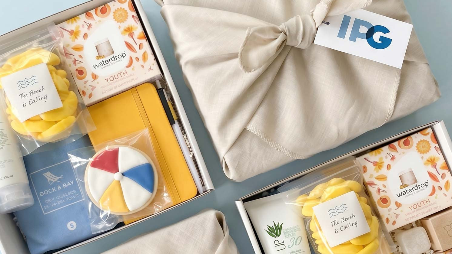 Gift set with soaps, sunscreen, and other items on a light blue background, featuring the IPG logo.