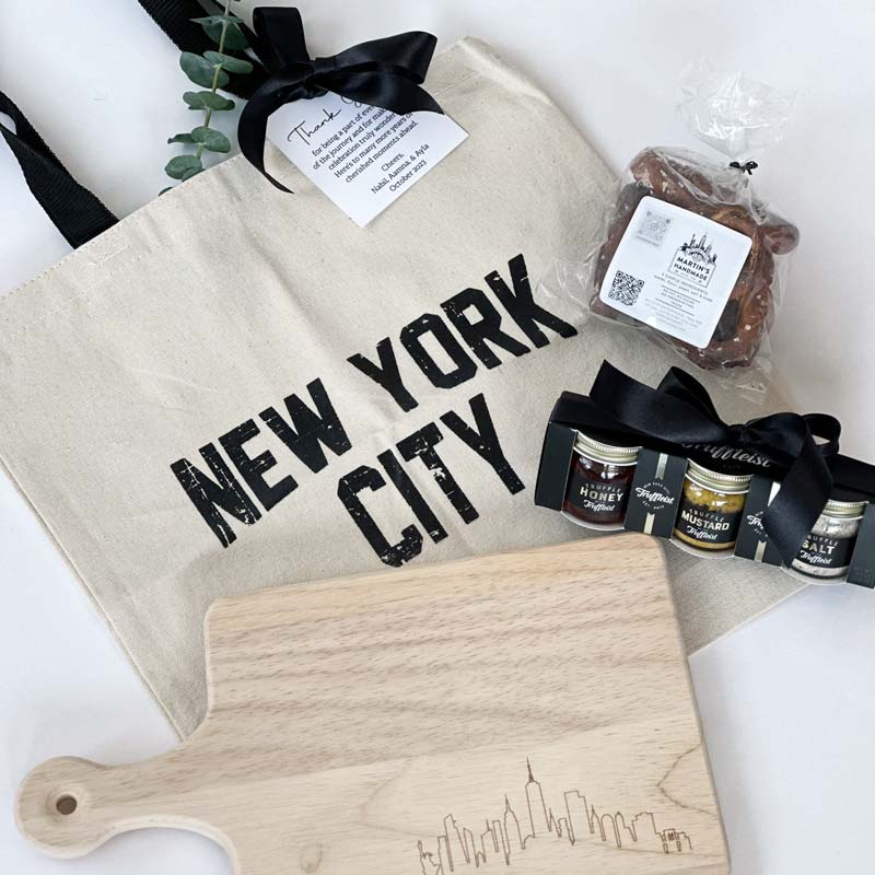 Custom New York City Gift bags for 50th birthday celebration. Gifts included NYC cutting board, trip spice jar, tote bag, pretzel and more