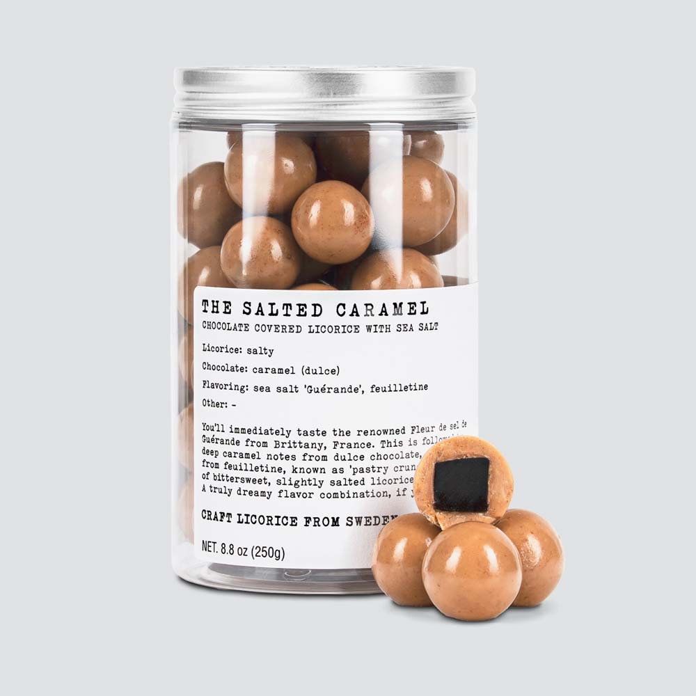 Jar of salted caramel chocolate covered liquorice with a label on a light gray background