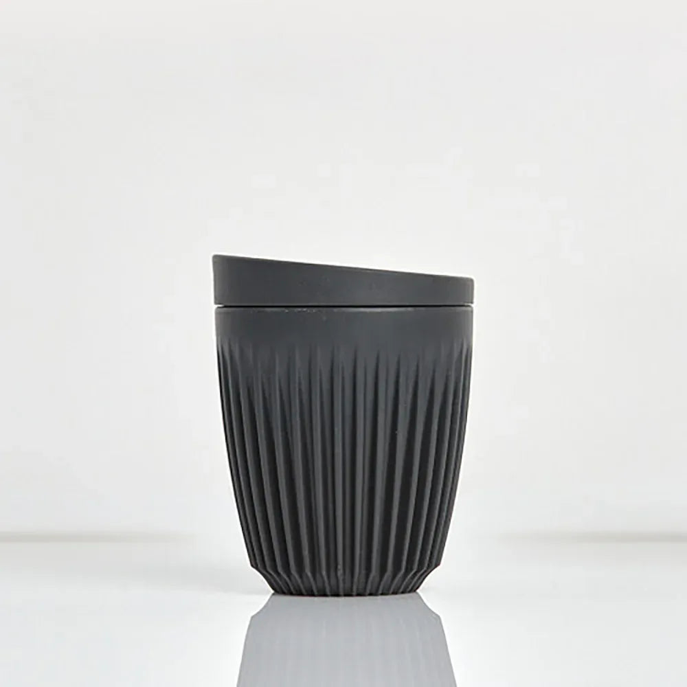 Charcoal colored Huskee cup with lid on a white background