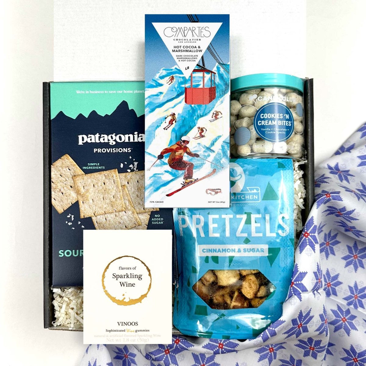 kadoo après ski holiday curated gift box with patagonia provisions cracker, pretzel, compartes hot cocoa marshmallow chocolate, wine gummy, cookies bites and more.