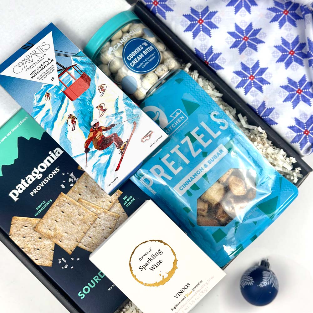 kadoo après ski holiday curated gift box with patagonia crackers, vinoos wine gummies, compartes hot cocoa chocolate bar, pretzels, candy club cookies cream bites and more