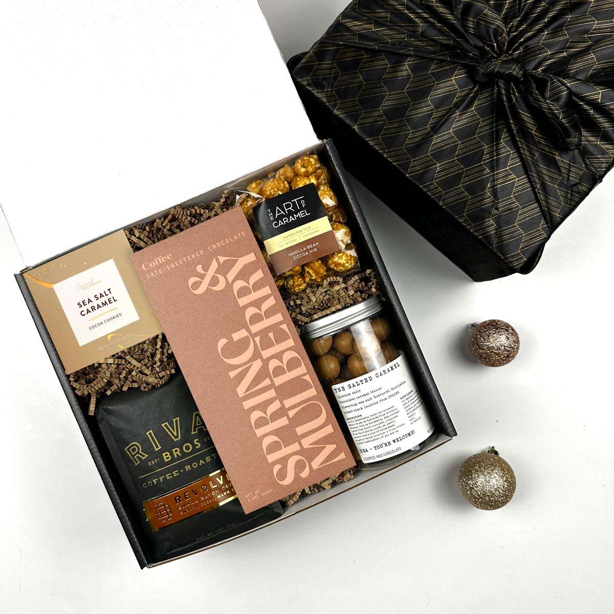 Gift box with Rival Bros coffee, Spring & Mulberry chocolate, and other snacks on a white background
