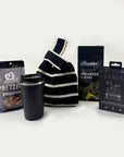 Black and white striped bag, black tumbler, pretzel packaging, coffee packaging, and wireless earbuds packaging on a white background.