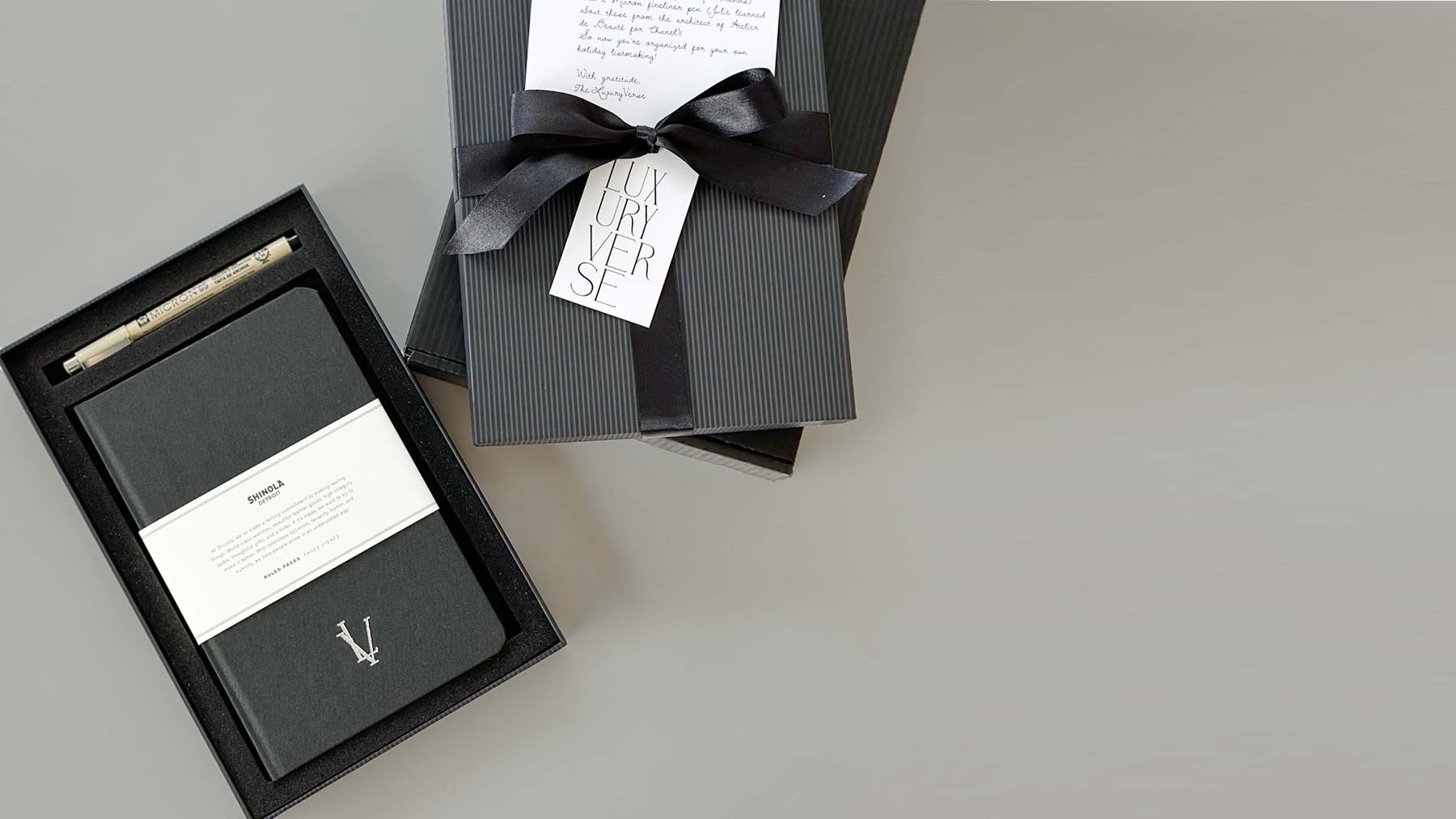 custom branded shinola notebook with micro pen in a black gift box and ribbon with custom hang tag and notecard