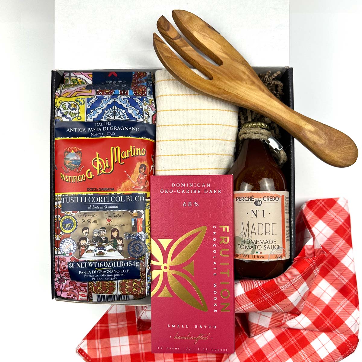 kadoo pasta night curated gift box with dry pasta, chocolate bar, homemade tomato sauce, yellow stripes kitchen towel, olive wooden fork utensil, red fabric wrap, and more