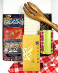 Kadoo Gift set with pasta, chocolate, and a wooden fork on a red checkered furoshiki cloth.