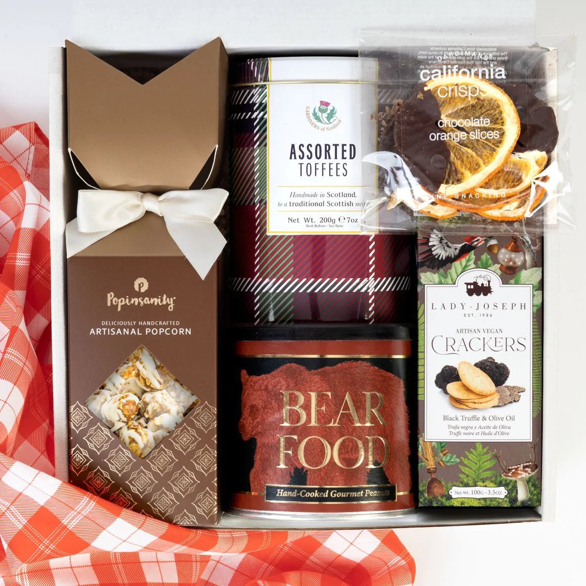 kadoo holiday sweater weather curated gift box with cinnamon swirl gourmet popcorn, assorted homemade toffees, cajun spice gourmet peanuts, dark chocolate california orange slices, artisan vegan crackers infused with olive oil and black truffle.