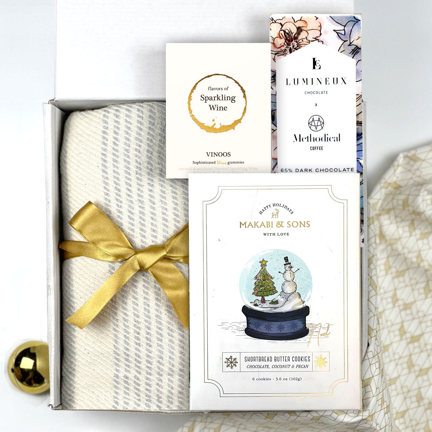 kadoo winter wonderland holiday curated gift box in furoshiki wraps. Gift items: chocolate, blanket, cookie, wine gummies and more.