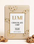 A box of Lumi Chocolate Chip bite-size cookies on a white background, with several chocolate chip cookies placed in front of the box.