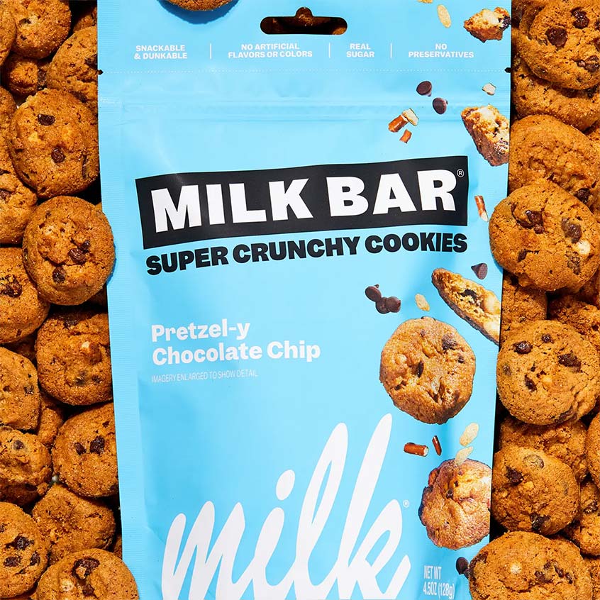 A bag of Milk Bar Super Crunchy Cookies, Pretzel-y Chocolate Chip flavor, surrounded by a border of chocolate chip cookies.