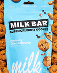 A bag of Milk Bar Super Crunchy Cookies, Pretzel-y Chocolate Chip flavor, surrounded by a border of chocolate chip cookies.