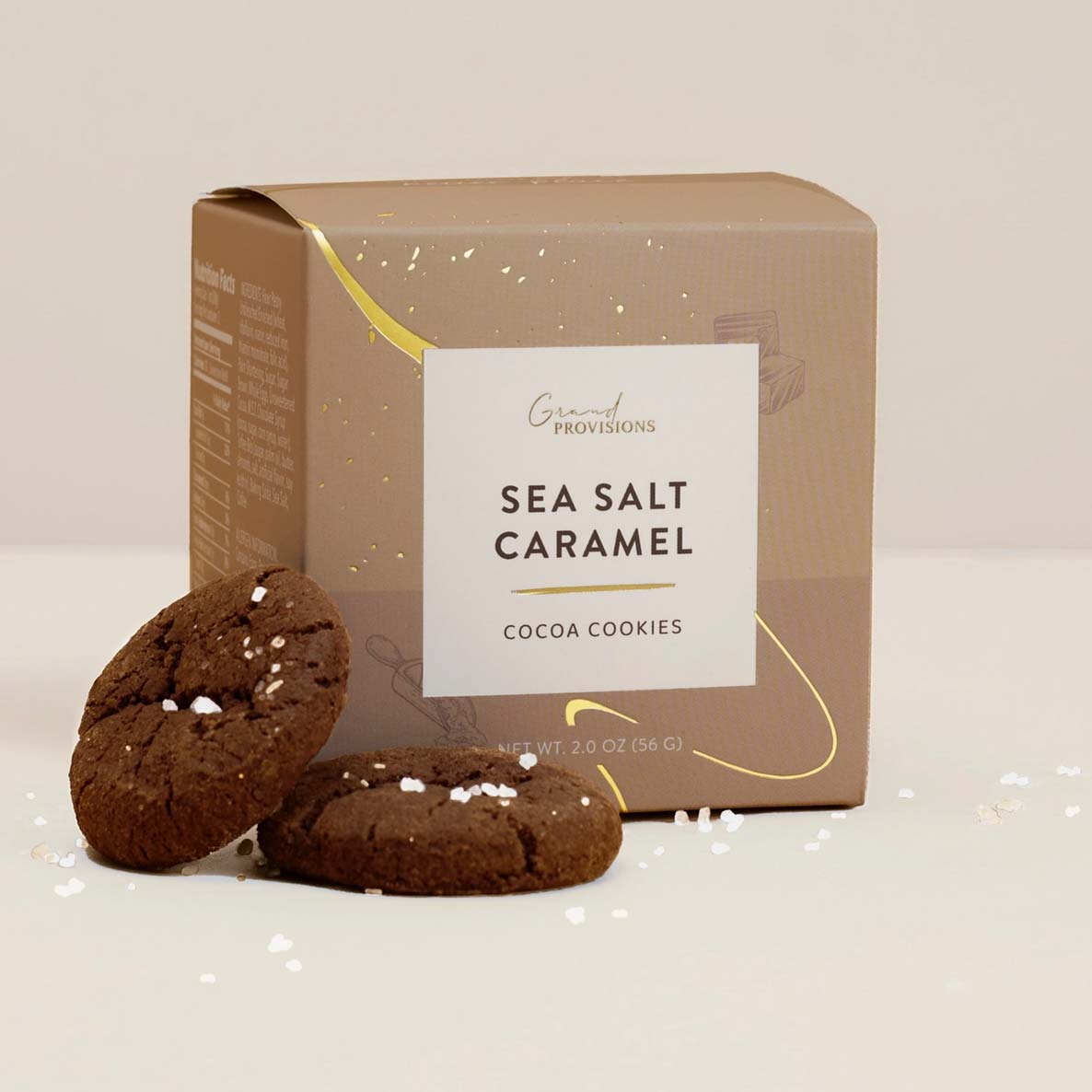 Box of Sea Salt Caramel Cocoa Cookies with two cookies in front on a light background